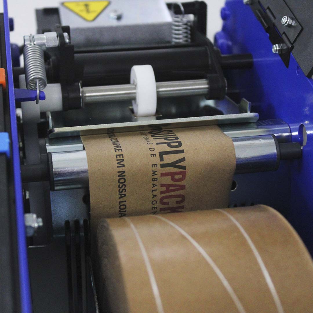 Mecanismo interno do Lapomatic com roletes e fita gomada personalizada passando